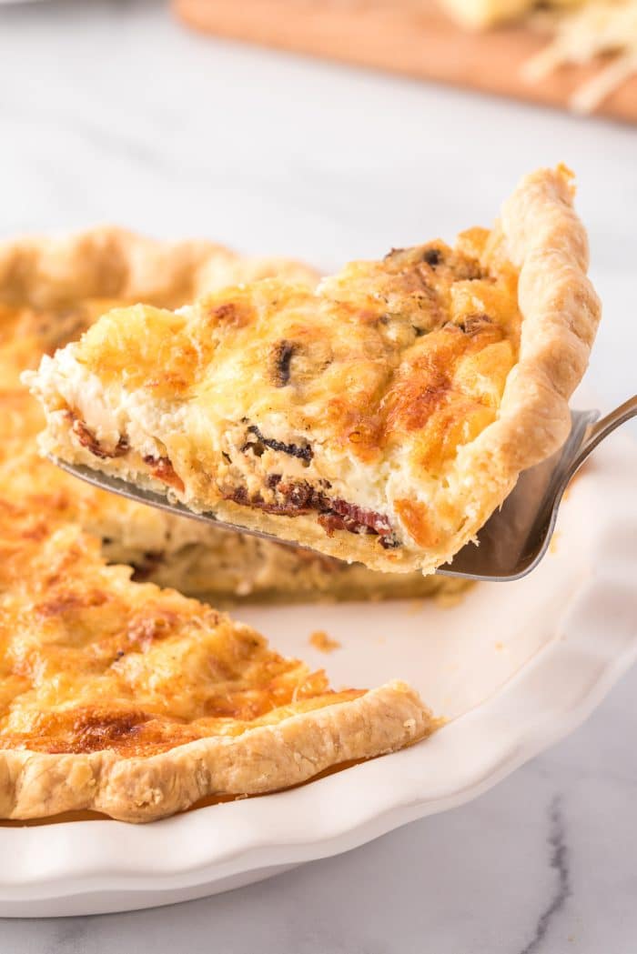 Serving a single slice of quiche lorraine.