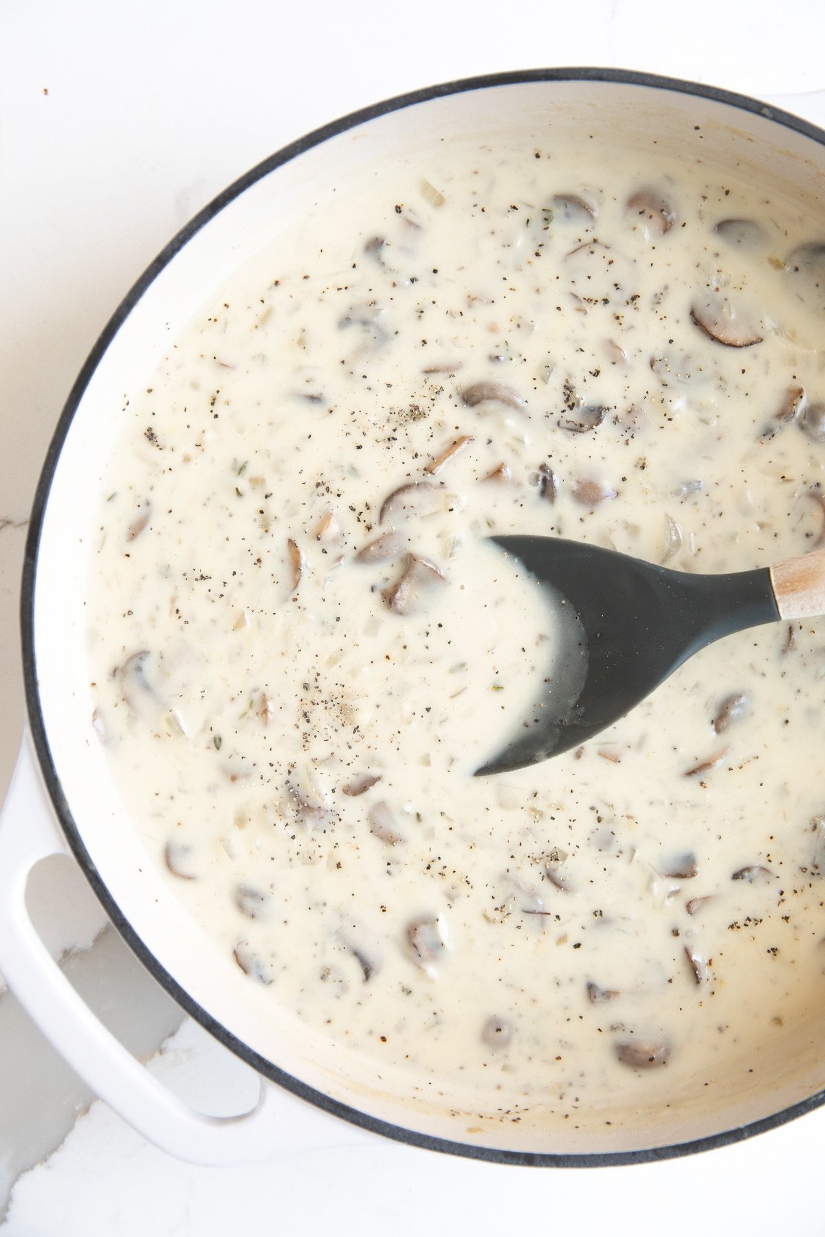 Large white saucepan filled with homemade mushroom soup sauce.
