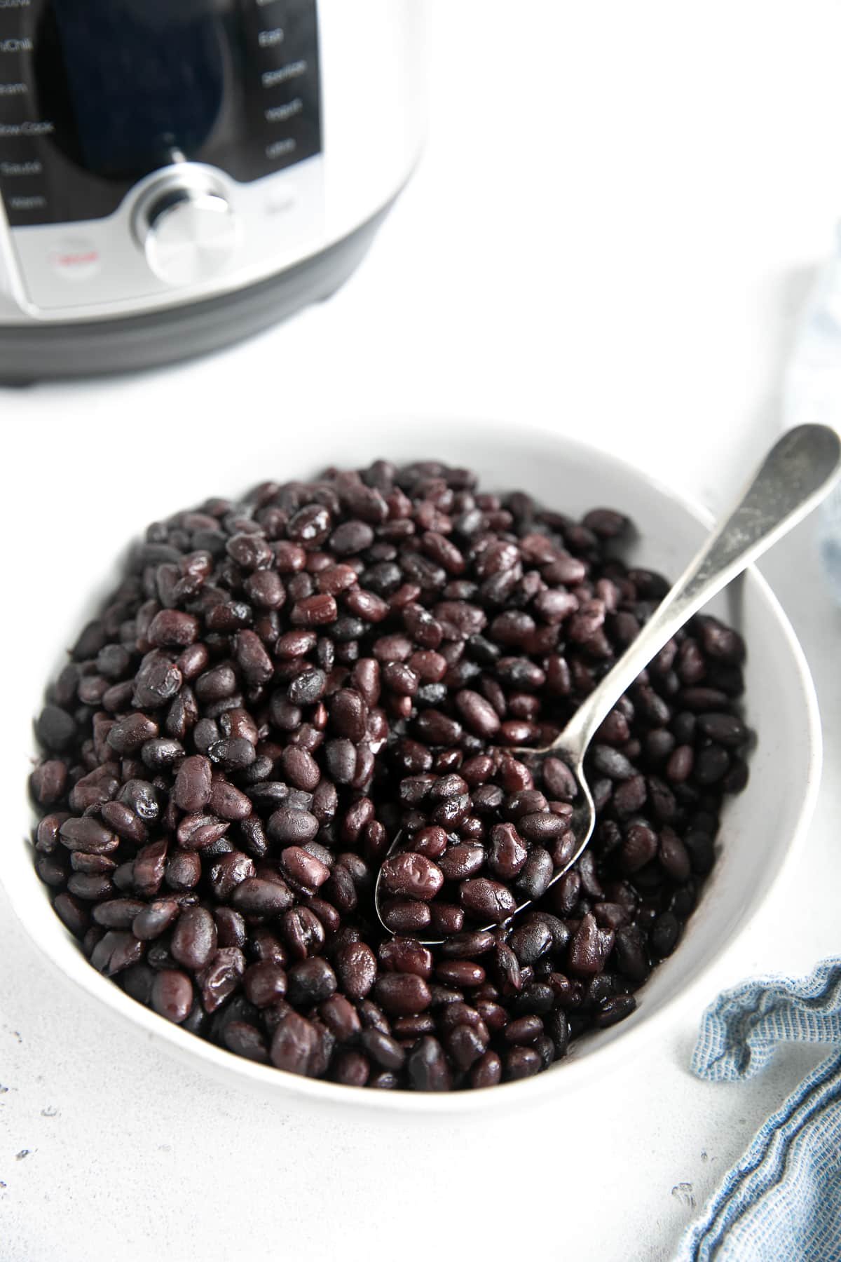 Image of cooked Instant Pot black beans in a white bowl.