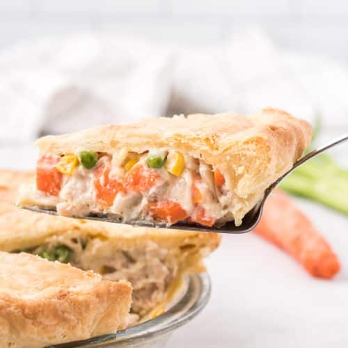 Image of a a single slice of chicken pot pie being removed from the whole pie.