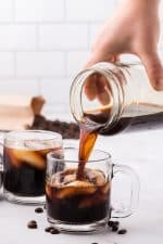 Image showing cold brew coffee being poured into a glass mug filled with ice.