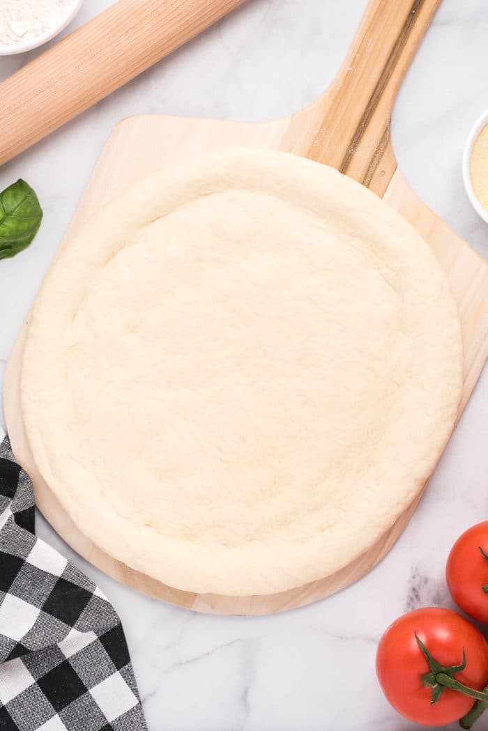 Image of homemade pizza dough rolled out on a pizza pan.