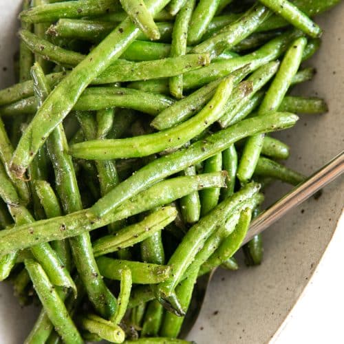 Oval serving dish filled with perfectly cooked air fryer green beans.