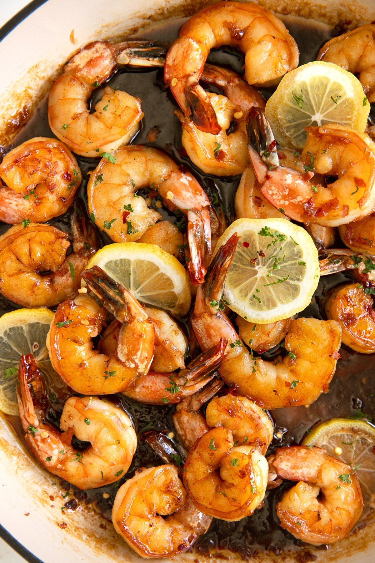 Overhead image of a large skillet filled with shrimp simmering in a sweet and tangy honey garlic sauce.
