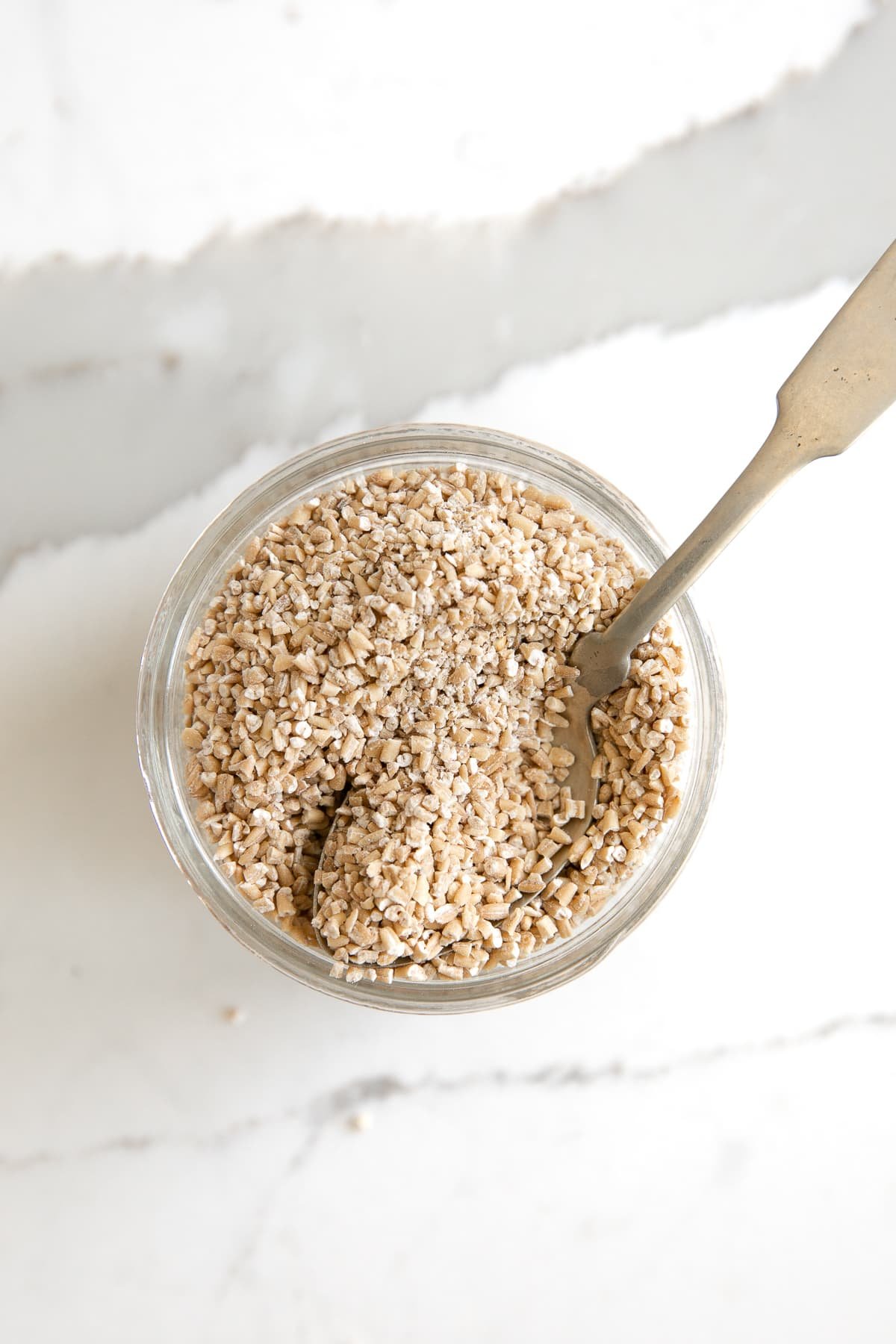 Image of a small glass jar filled wit uncooked steel cut oats.