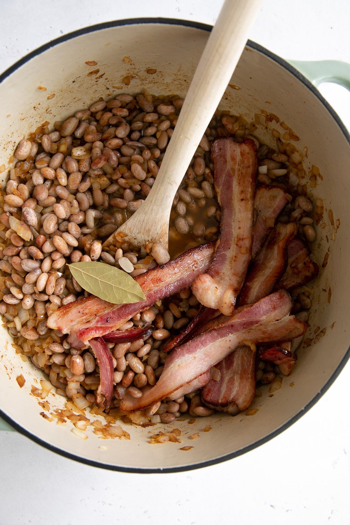 Large pot filled with dry pinto beans and bacon.