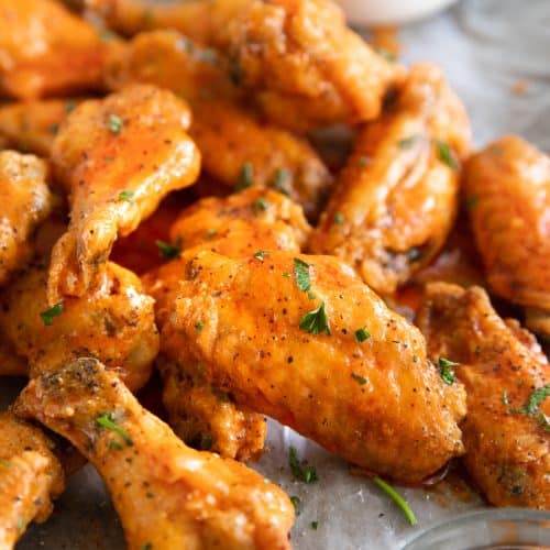 Close up image of buffalo chicken wings covered in buffalo sauce.