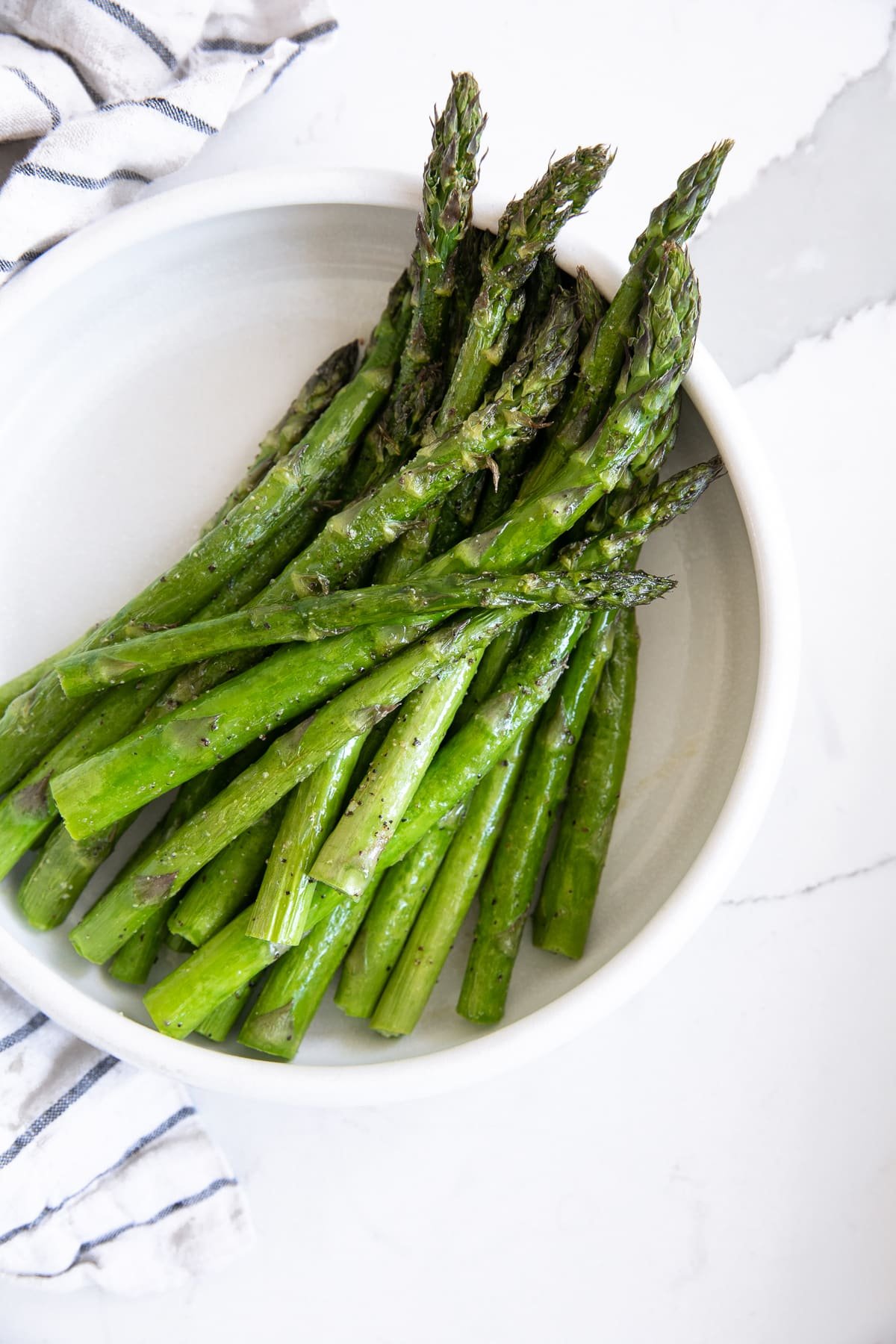Small plate filled with approximately 1 pound asparagus cooked in the air fryer.