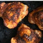 Crispy, golden-brown air fryer chicken thighs arranged in an air fryer basket, perfectly seasoned and cooked for a flavorful, easy dinner.