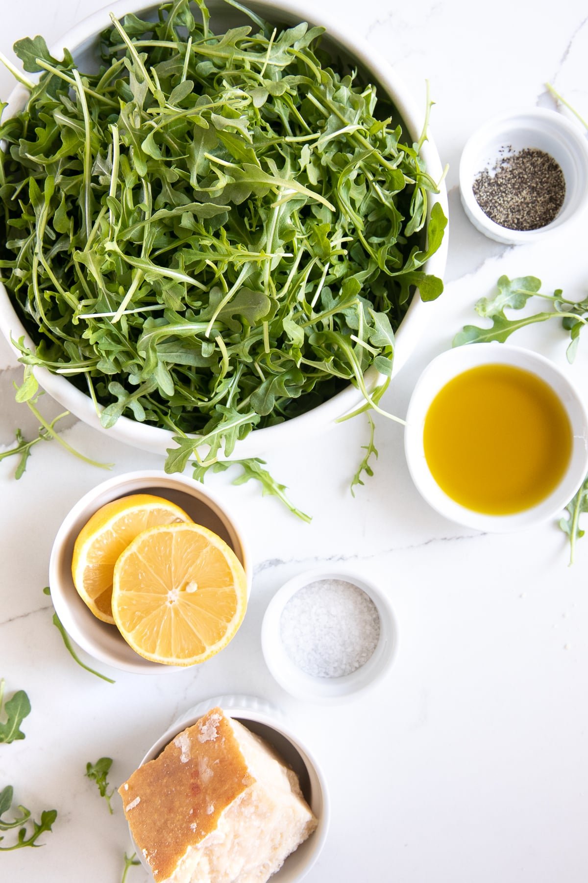 Ingredients for simple arugula salad in individual serving dishes.