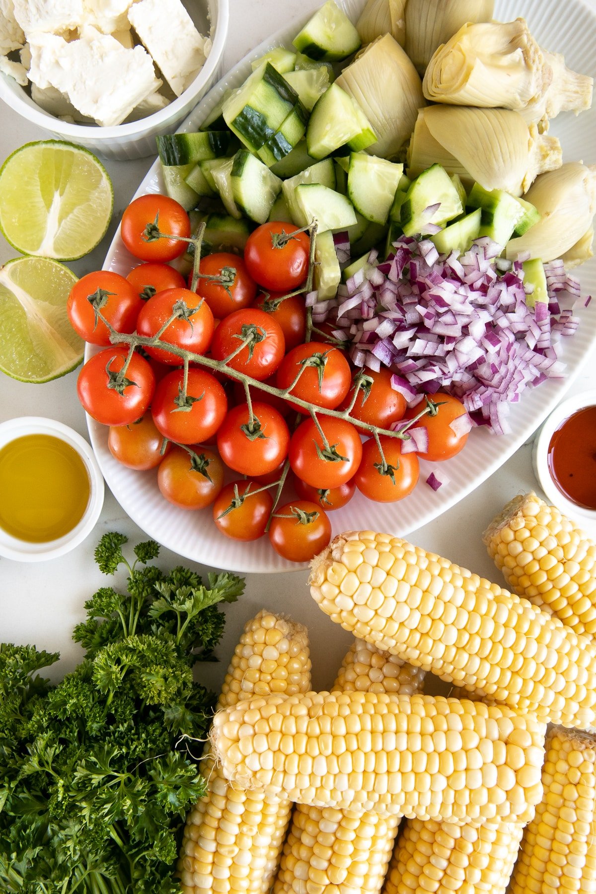 Ingredients in corn salad spread out over a large white table.