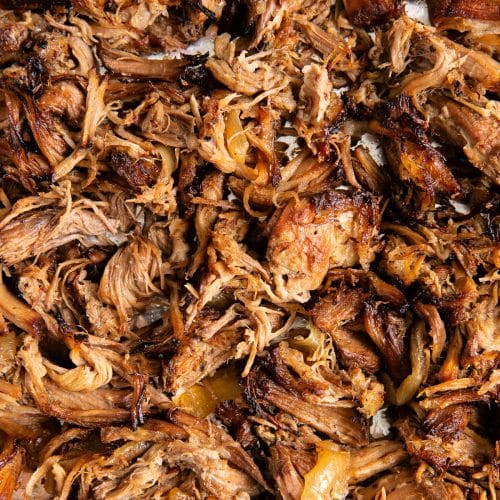 Shredded crispy pulled pork carnitas on a large baking sheet.