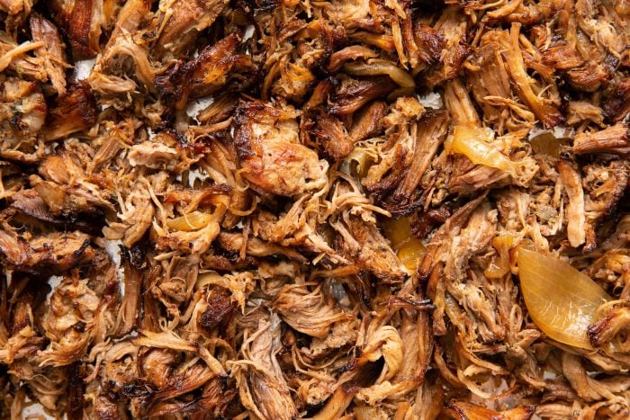 Shredded crispy pulled pork carnitas on a large baking sheet.