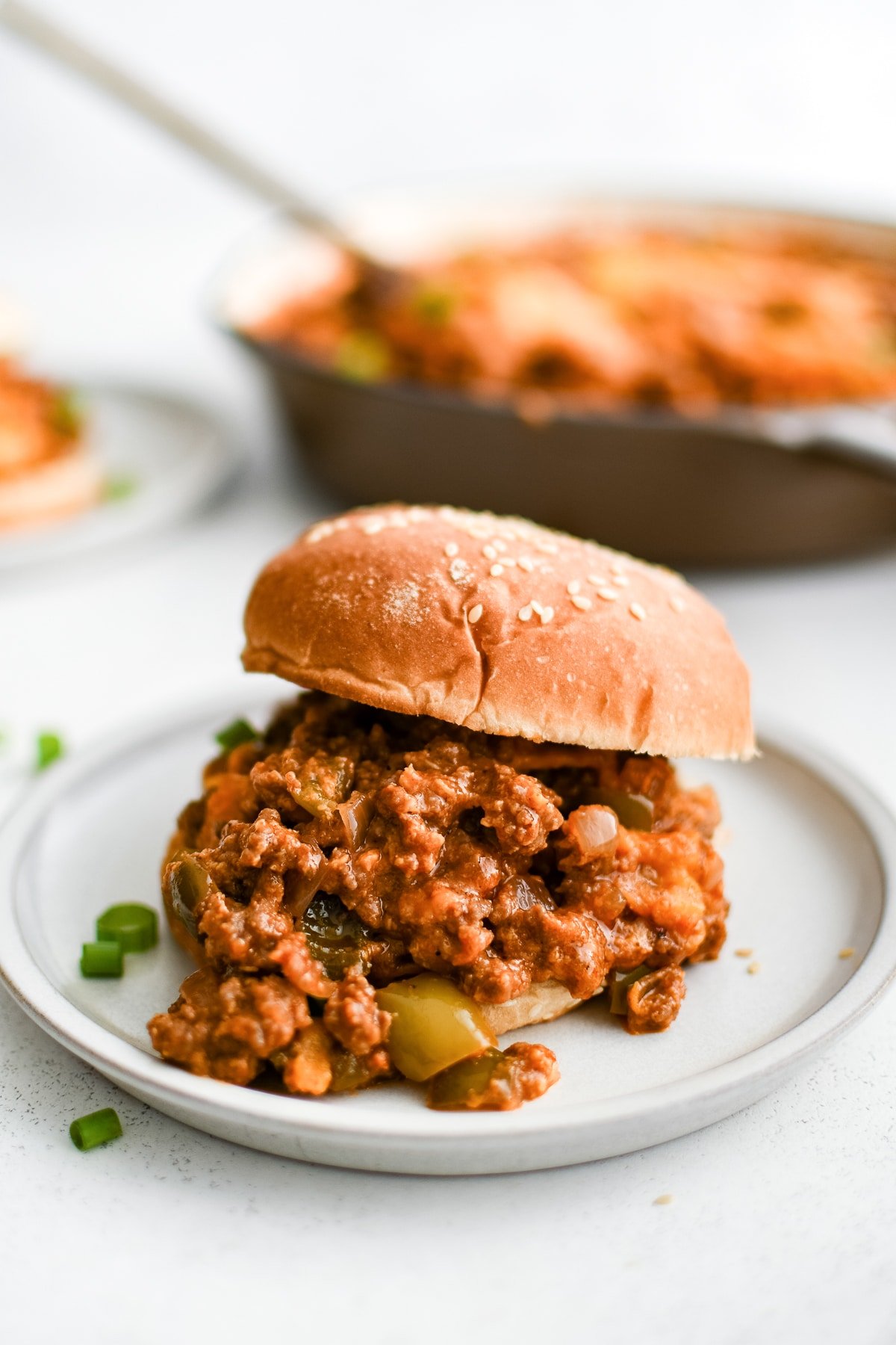 Homemade sloppy joe mixture sandwiches between a toasted hamburger bun.