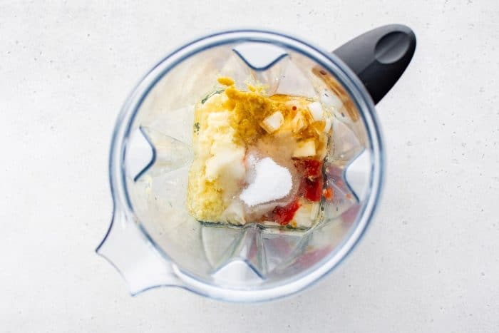 Overhead of blender filled with ginger dressing ingredients before blending.