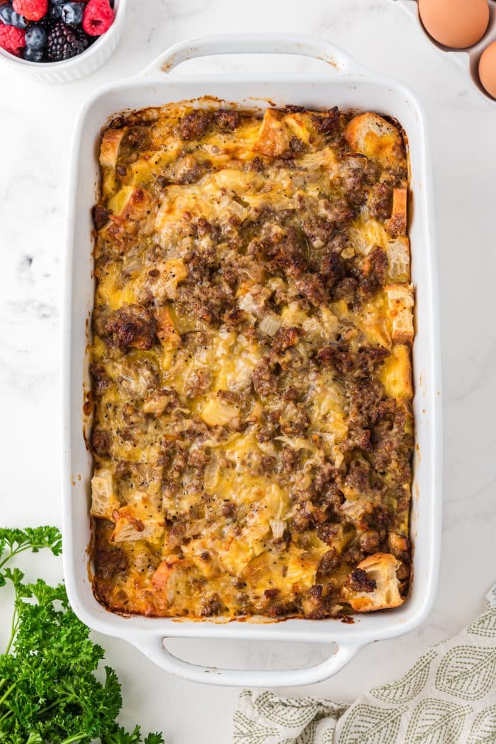 Egg, sausage, and cheese breakfast casserole in a large white baking dish.