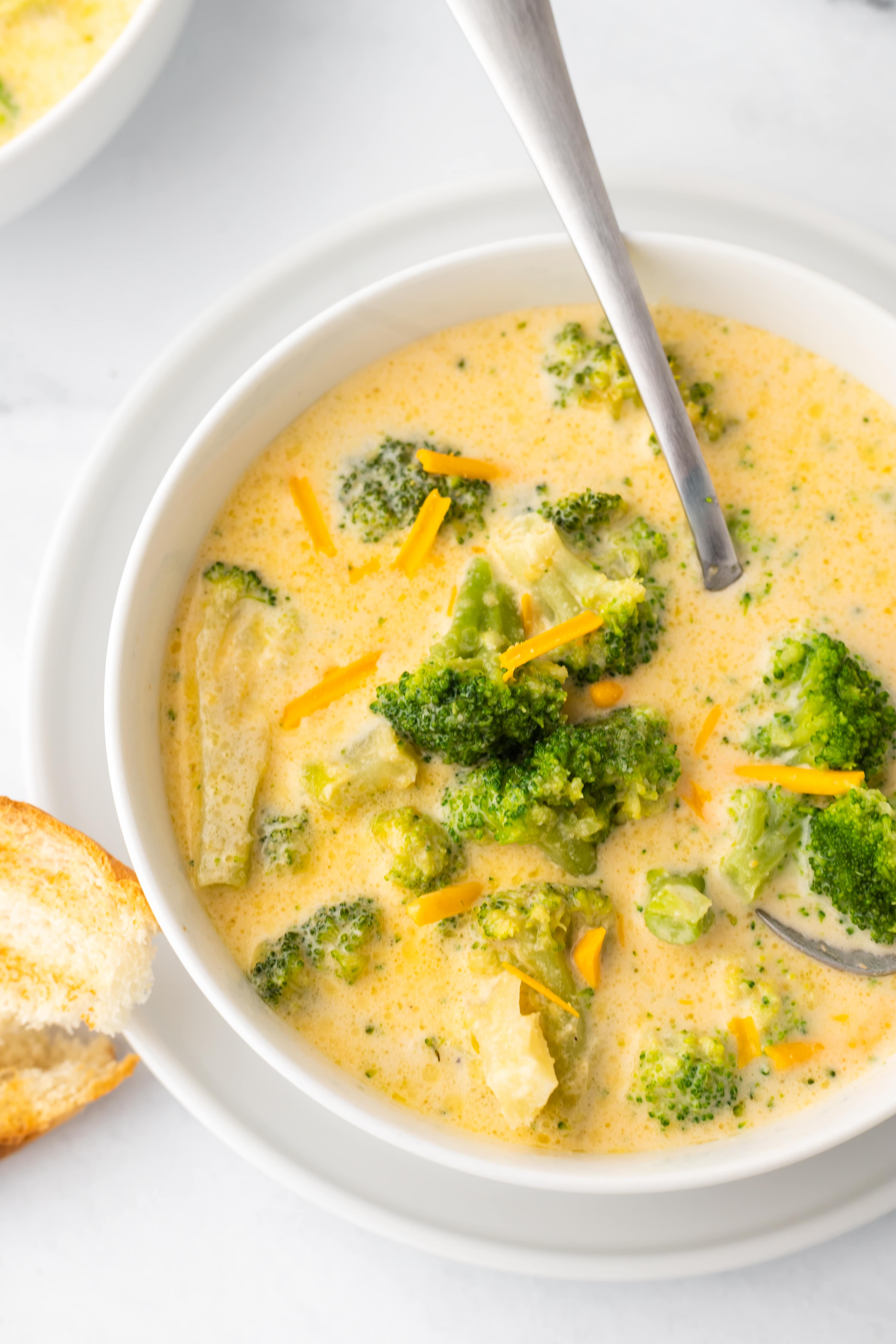 White soup bowl filled with broccoli cheddar soup.