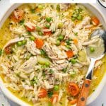 Chicken and orzo soup topped with herbs and lemon slices, labeled โLemon Chicken Orzo Soup.โ