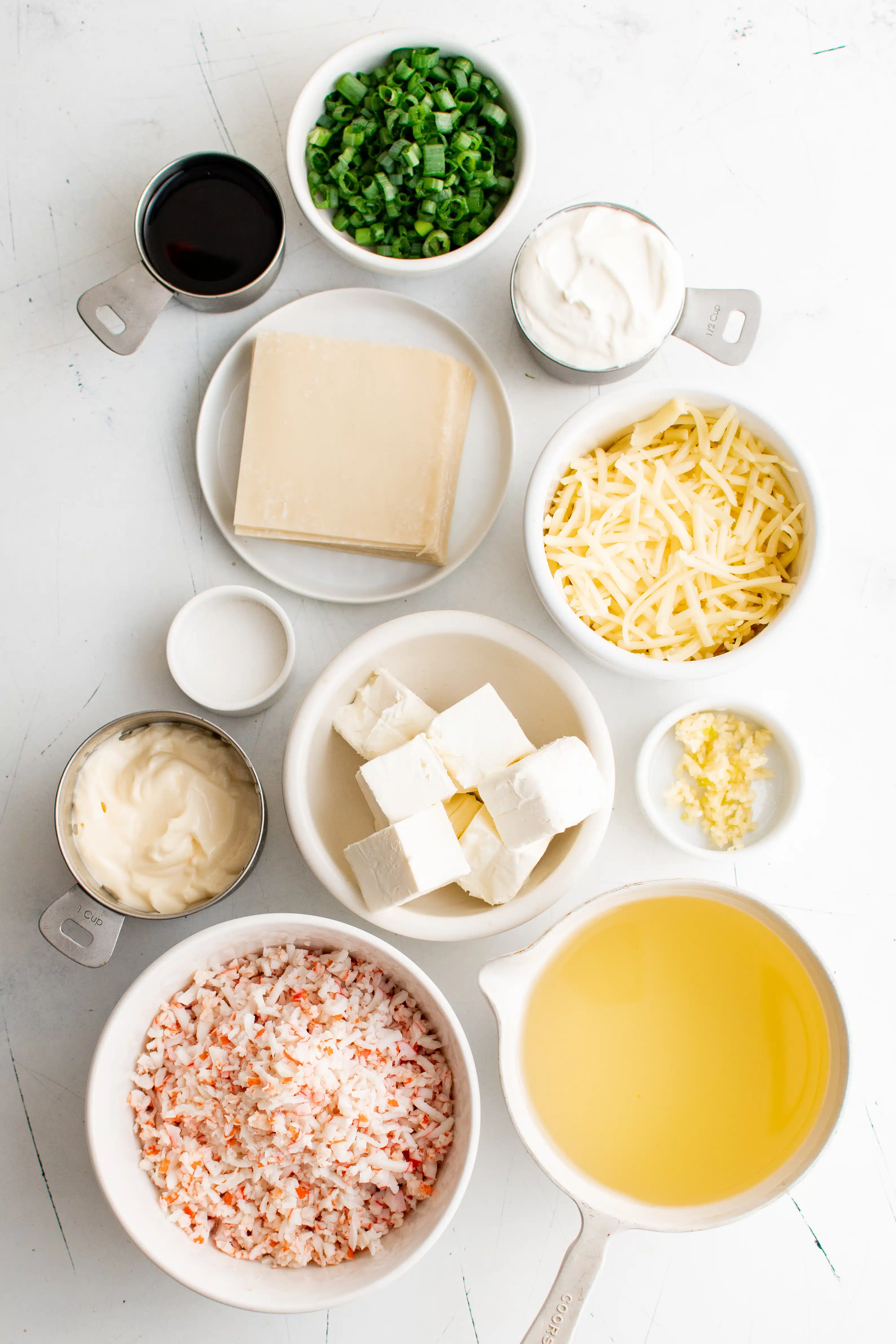Ingredients for crab rangoon dip set aside in individual bowls.