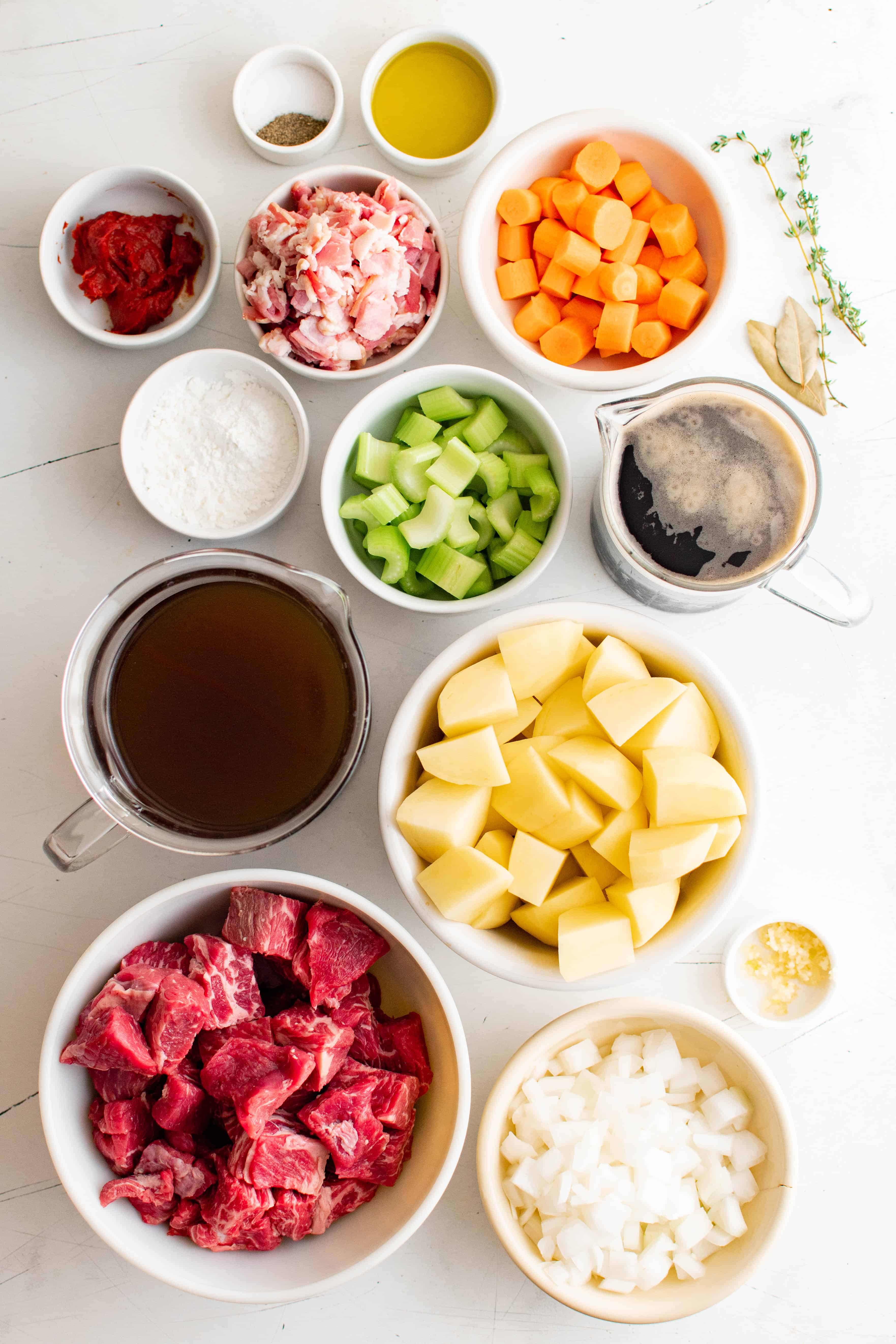 Ingredients for traditional Guinness beef stew measured out and set aside in individual serving bowls.