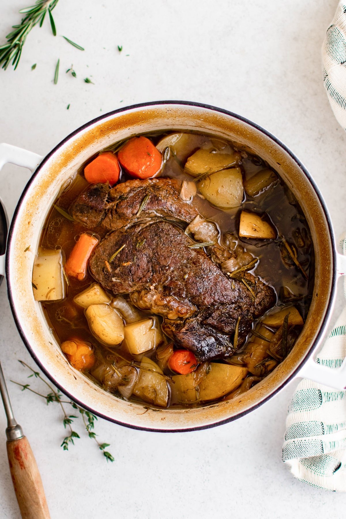 Dutch oven pot roast made with potatoes, carrots, and beef chuck roast just out of the oven.