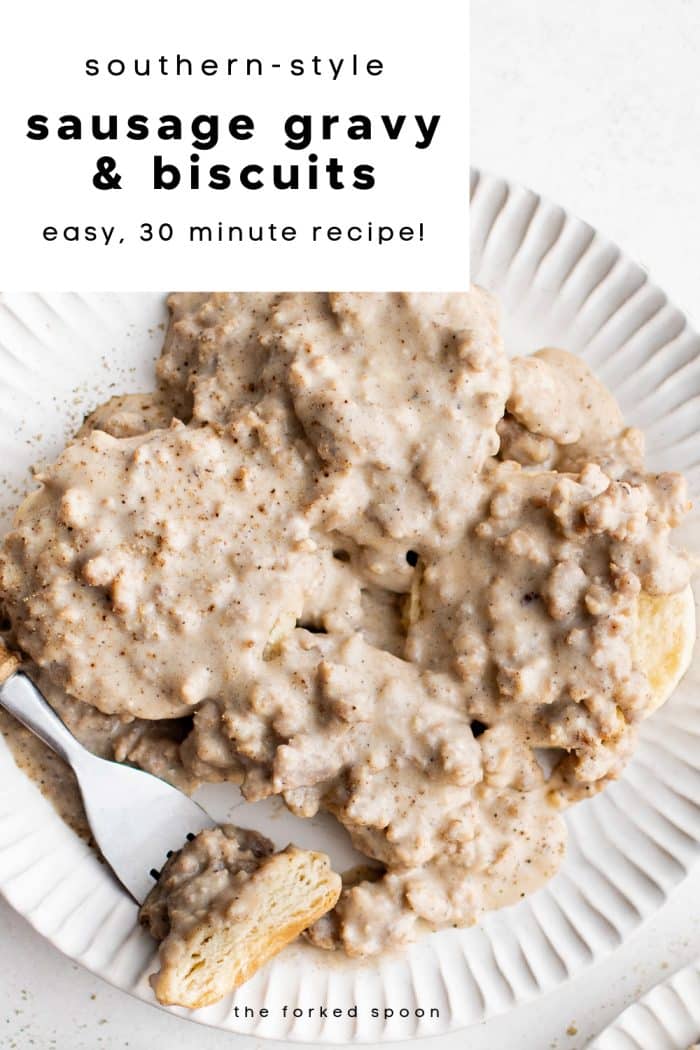 Southern-style sausage gravy poured over fluffy homemade biscuits on a white plate with a fork.