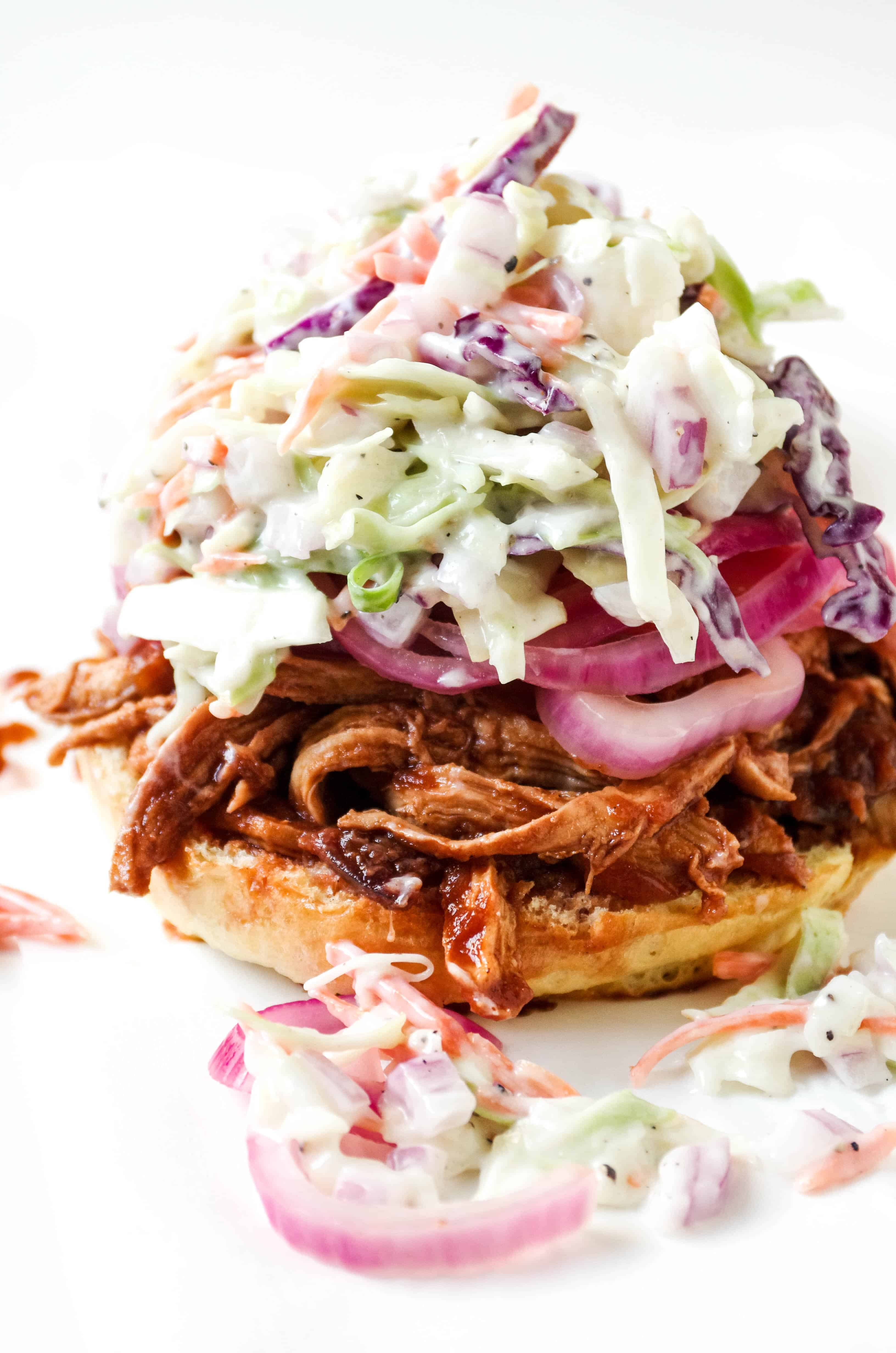 Sliced brioche bun topped with shredded cherry bbq chicken, pickled red onions, and creamy coleslaw.