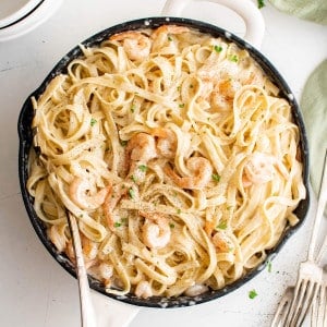 Large skillet filled with creamy shrimp alfredo with fettuccine pasta.