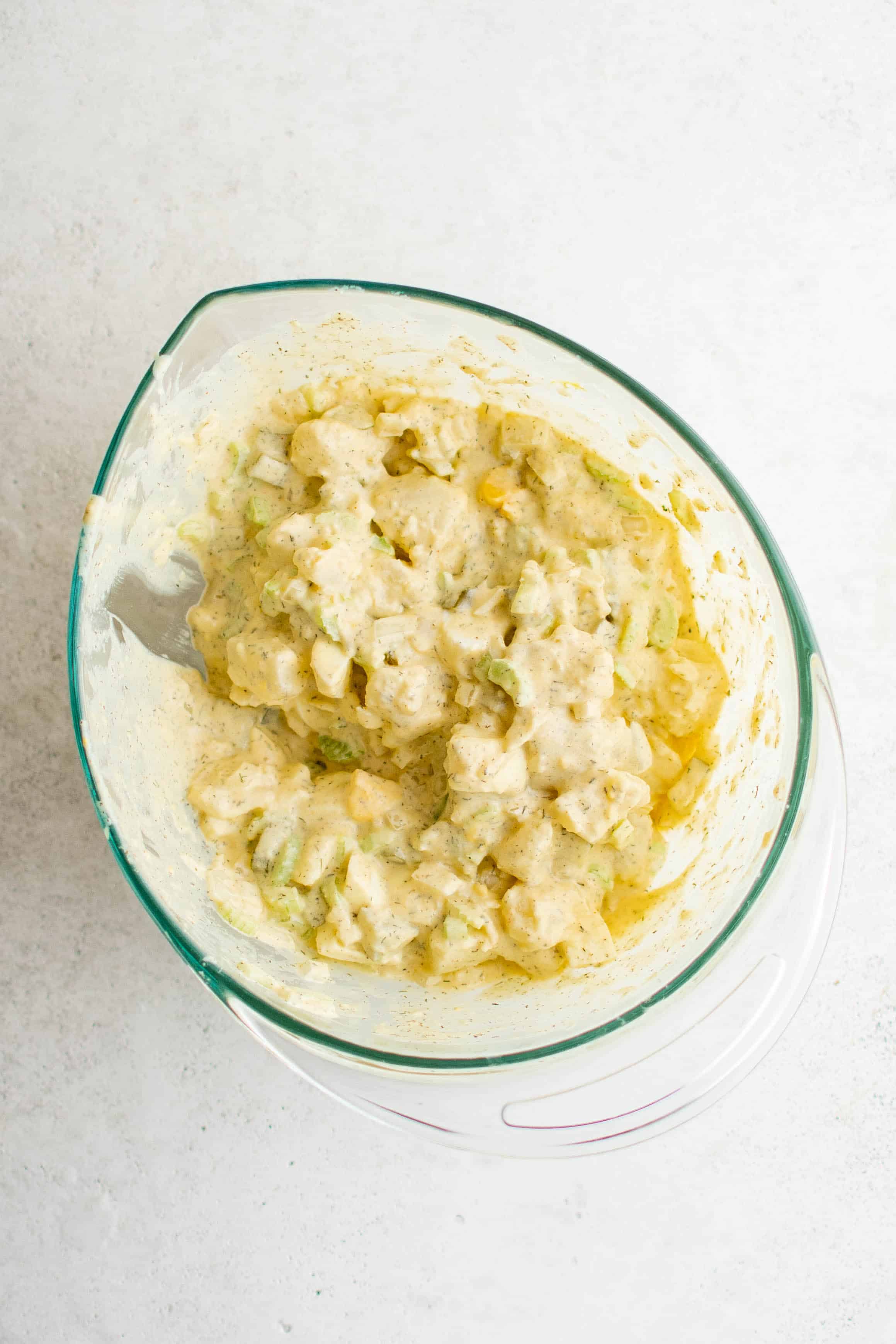 Prepared potato salad mixed together in a mixing bowl.