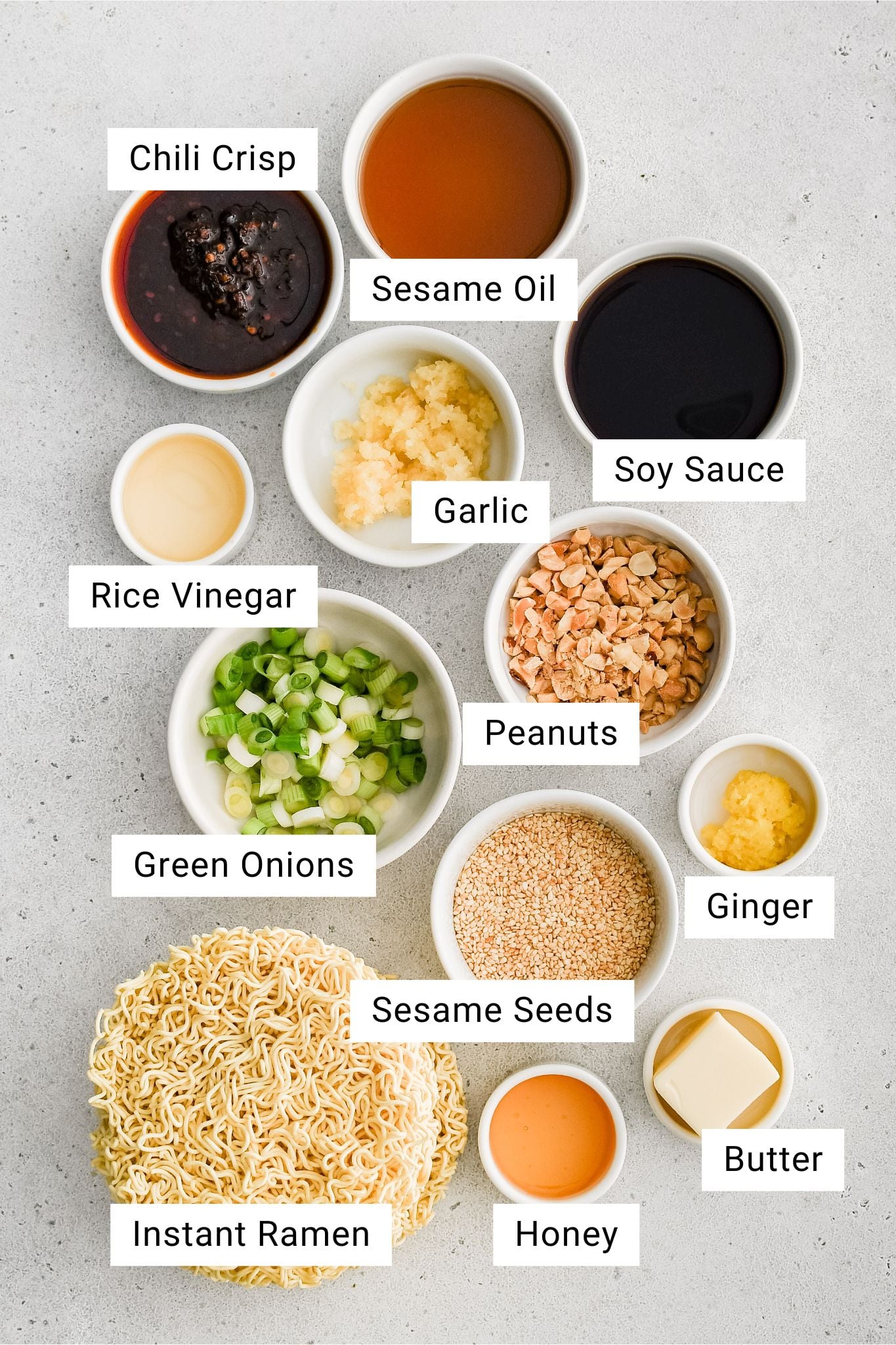 Ingredients for spicy ramen noodle recipe measured and set aside in individual serving bowls with text overlay.