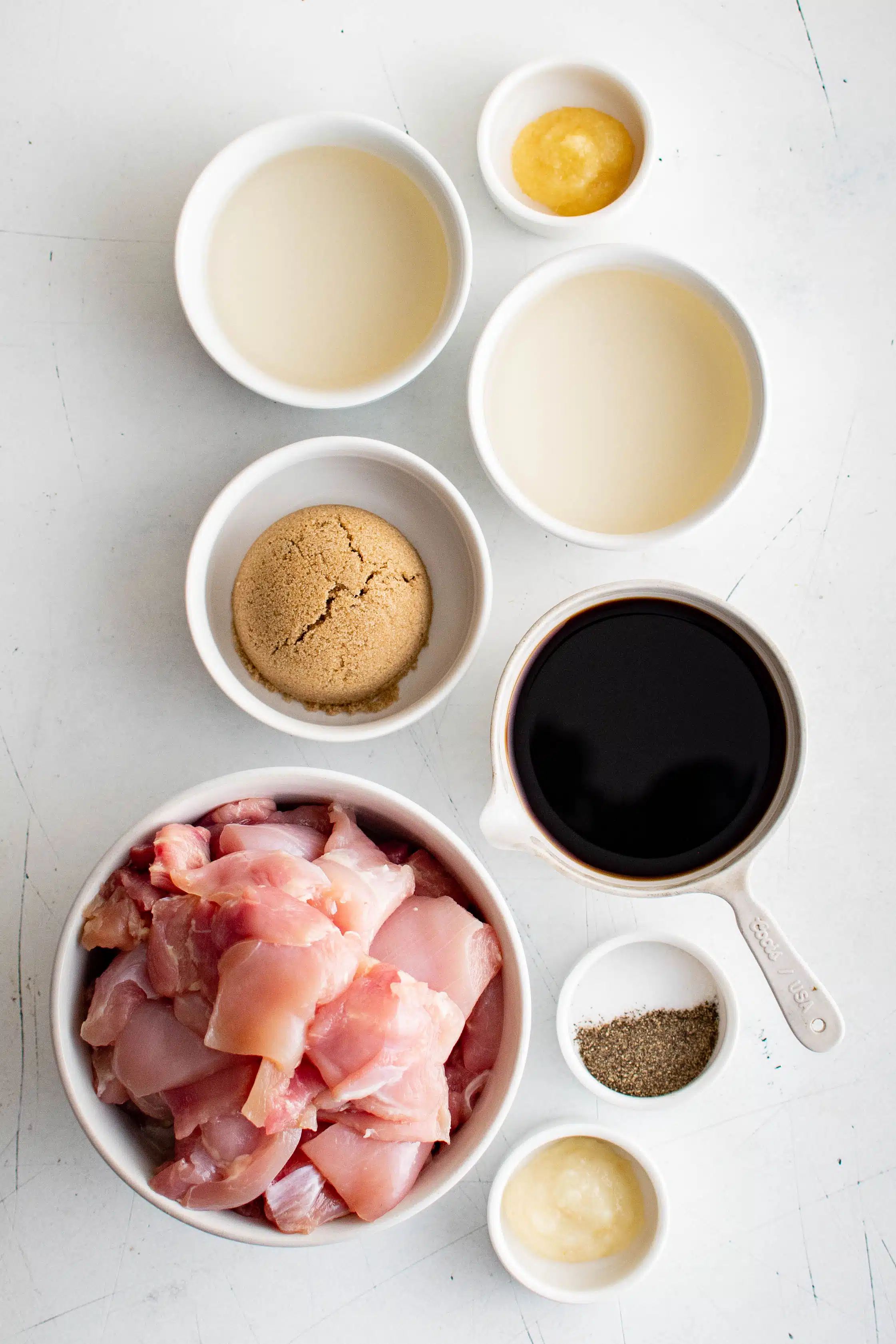 Ingredients needed to make chicken yakitori in individual serving dishes.