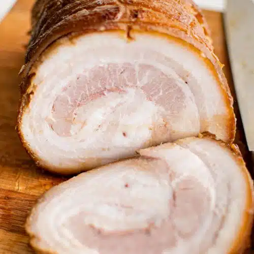 Thinly sliced chashu pork on a large cutting board.