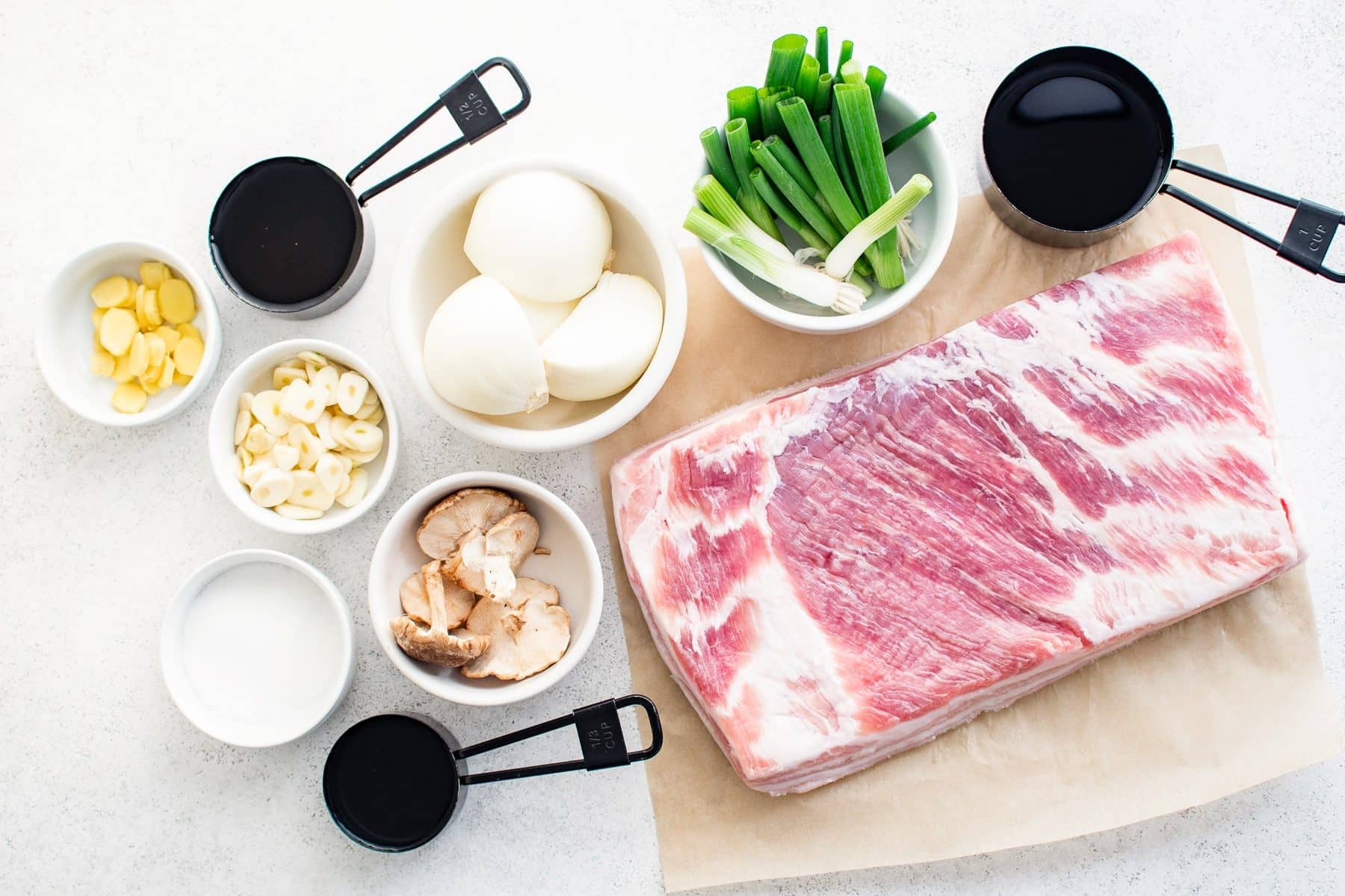 Ingredients needed to make Chashu pork displayed in separate bowls on a large table.