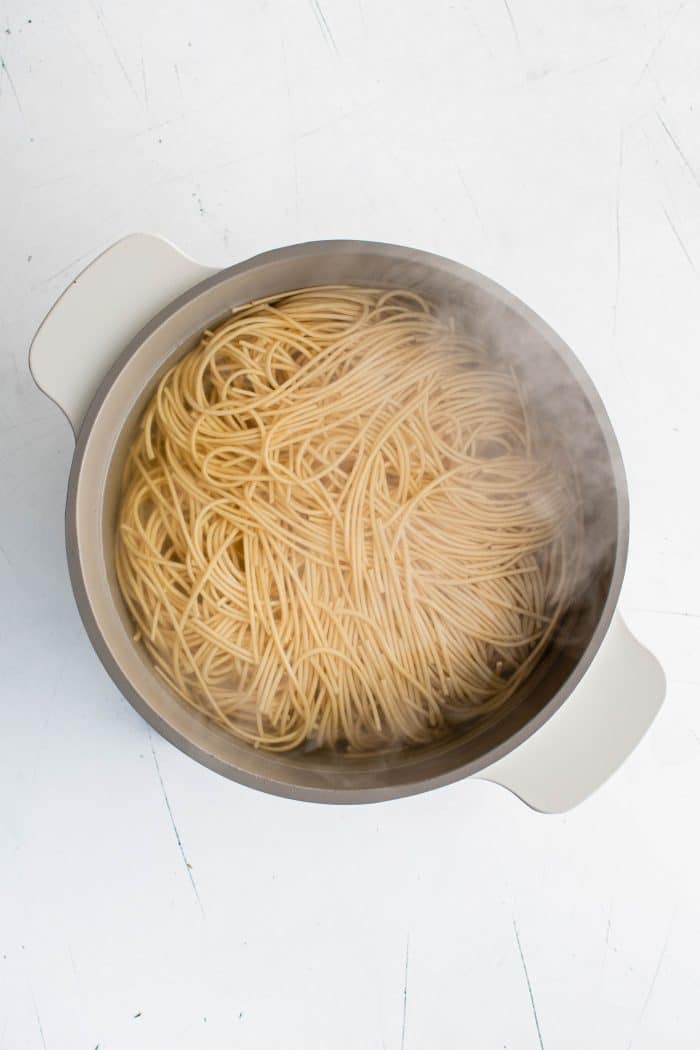 Ramen noodles cooking in a large pot filled with boiling water.