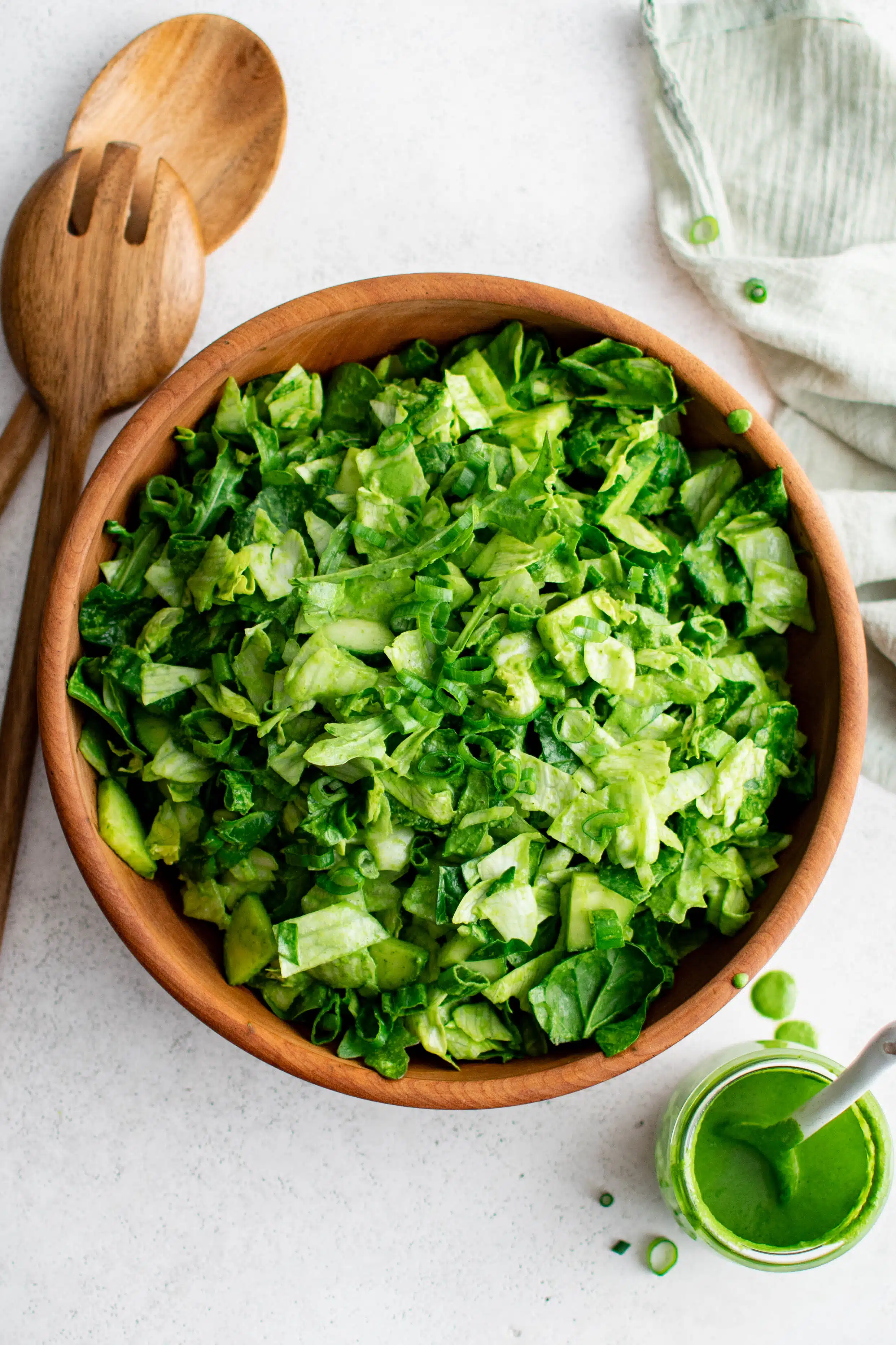 Beautiful, bright chopped green goddess salad in a wood salad serving bowl.