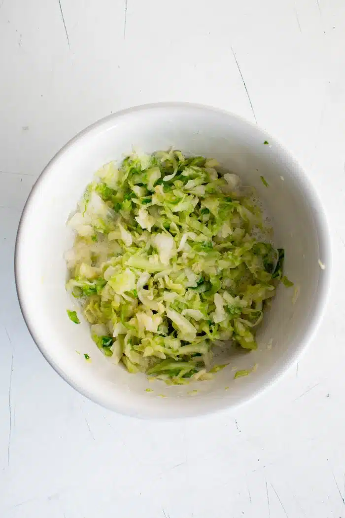 Process of massaging shredded cabbage with salt.