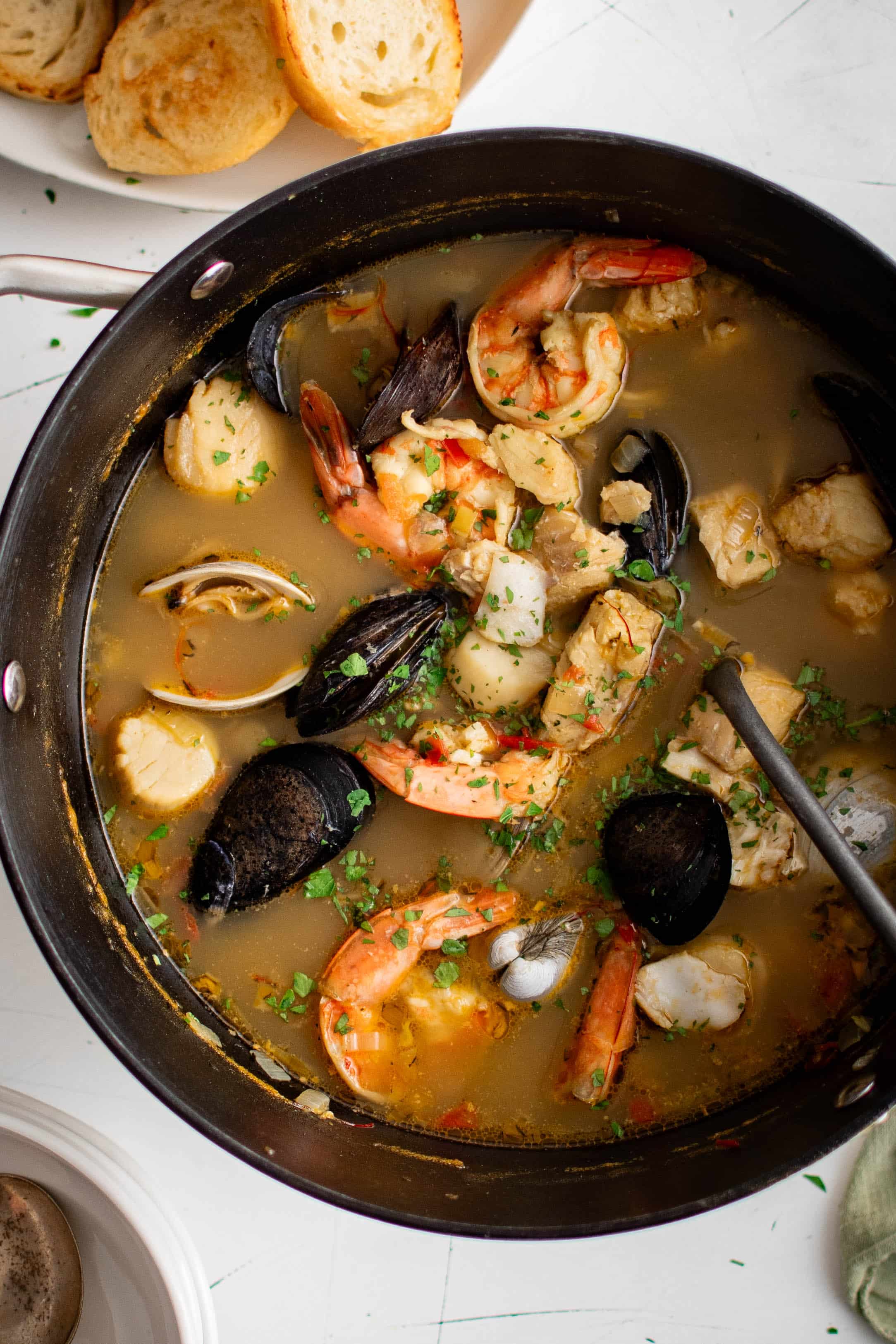 Overhead image of a large pot filled with bouillabaisse, a French soup made with fish and fresh seafood.