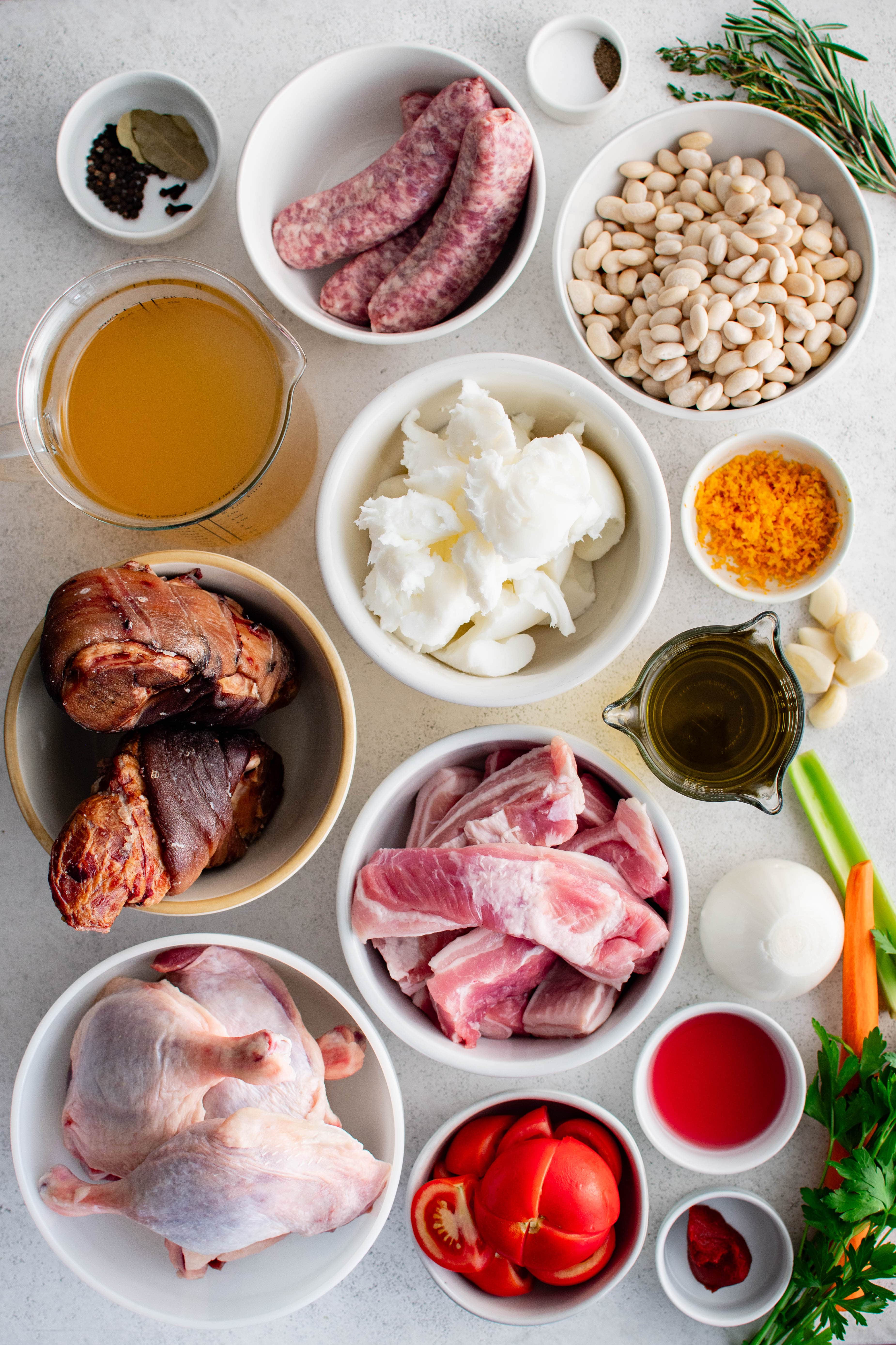 Ingredients needed to make a traditional French Cassoulet Recipe in individual measuring cups and ramekins.