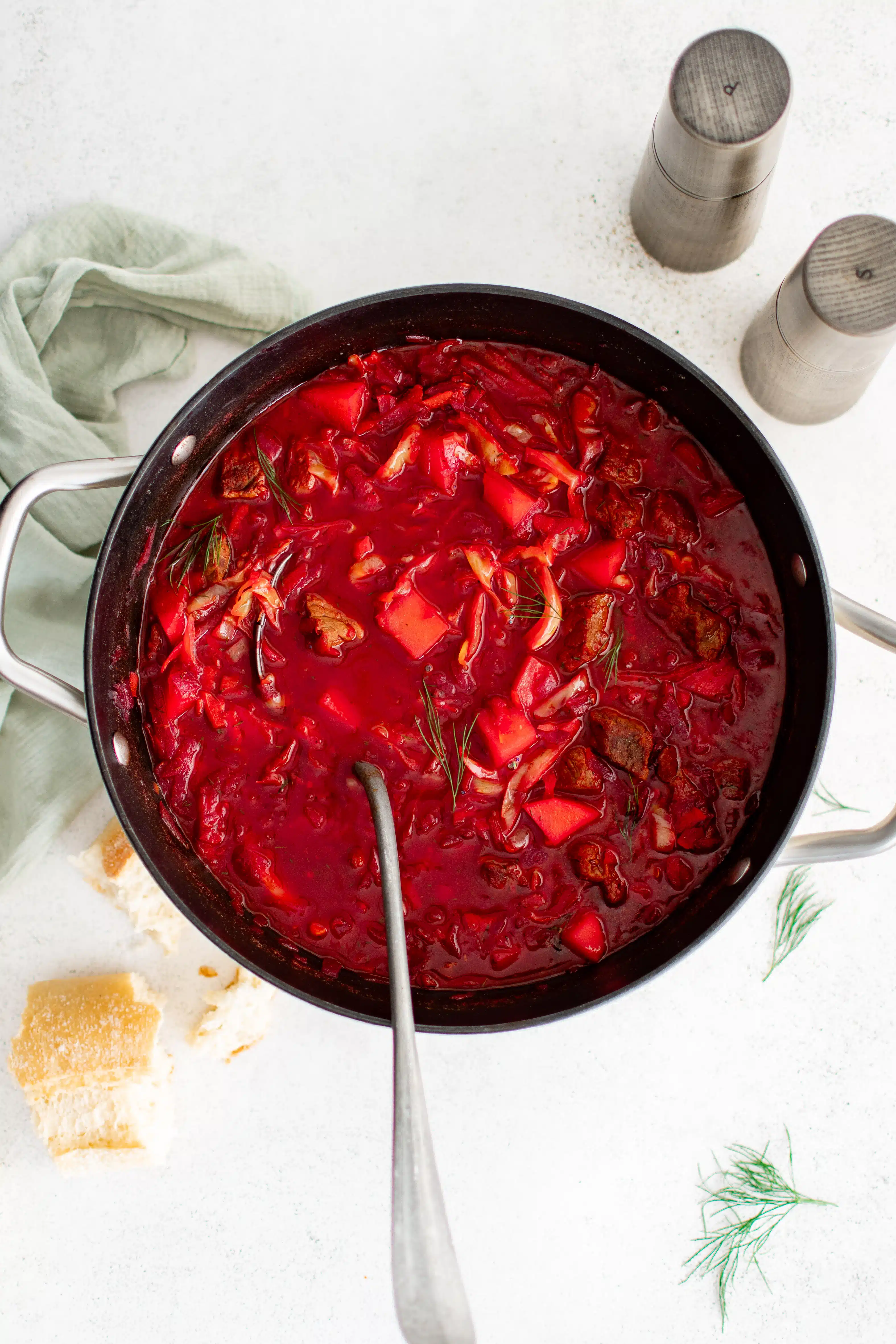 Large soup pot filled with bright red and pink simmering Ukrainian borscht soup.
