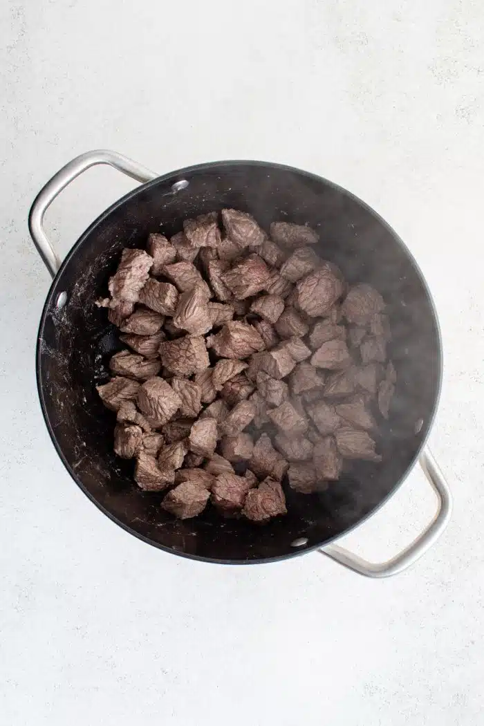 Large pot filled with cooking stew meat.