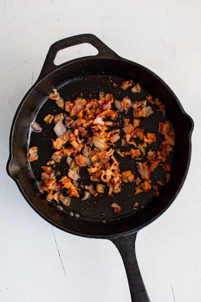 Crispy cooked bacon in a large cast iron skillet.