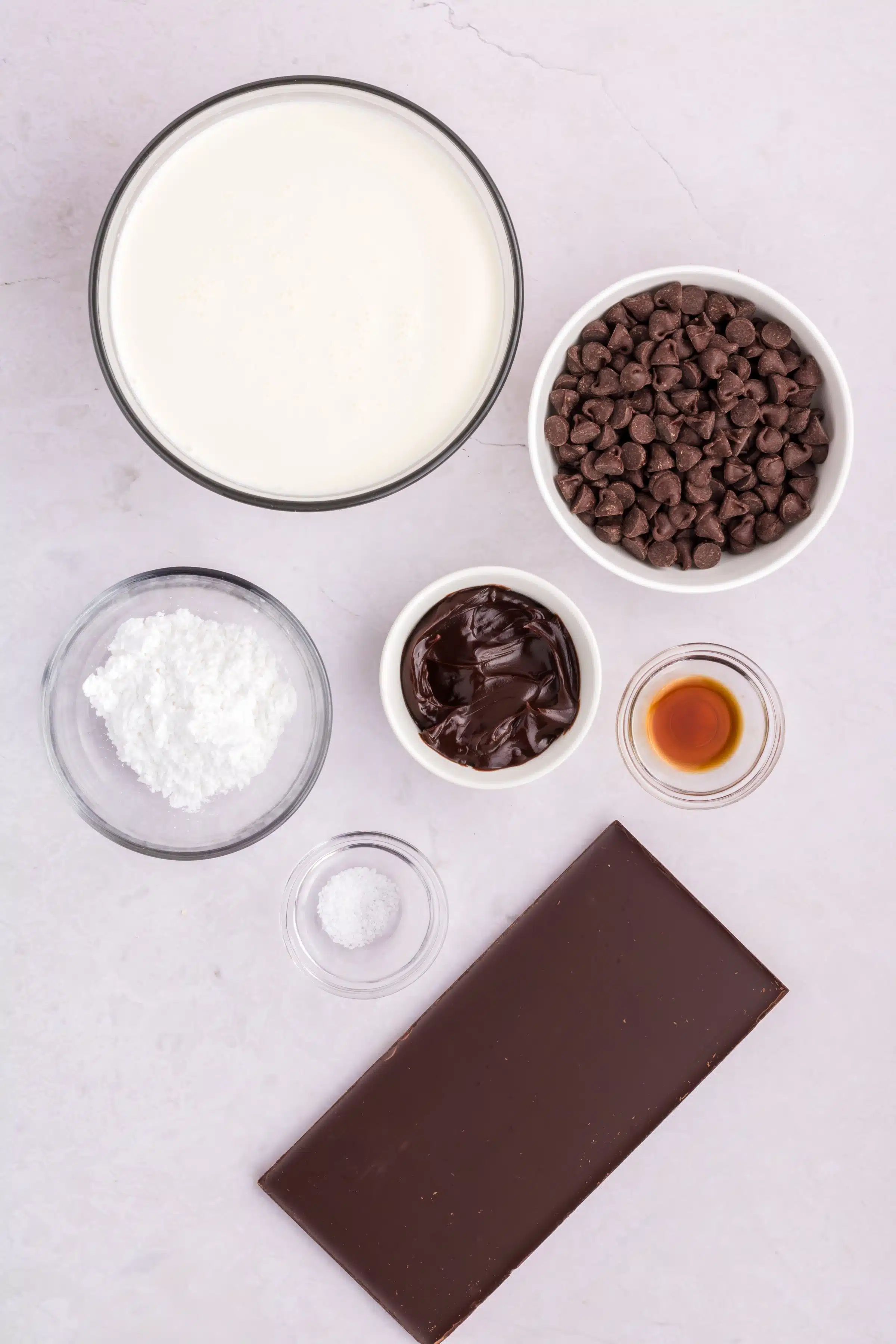 Ingredients needed to make Chocolate Mousse  in a bowl in individual measuring cups and ramekins.