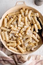 Large pan filled with Pasta Alla Gricia and sprinkled with fresh Pecorino Romano Cheese.