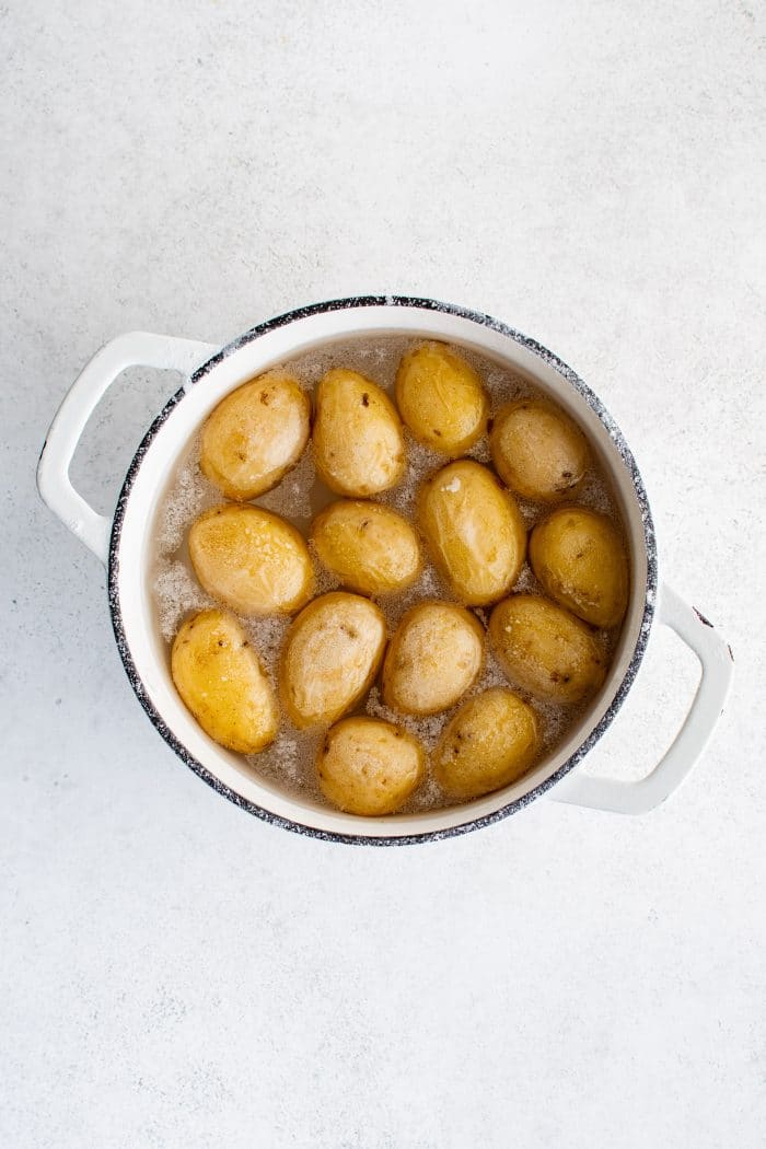 Overhead image of boiled and cooked salt potatoes in boiling salt water/