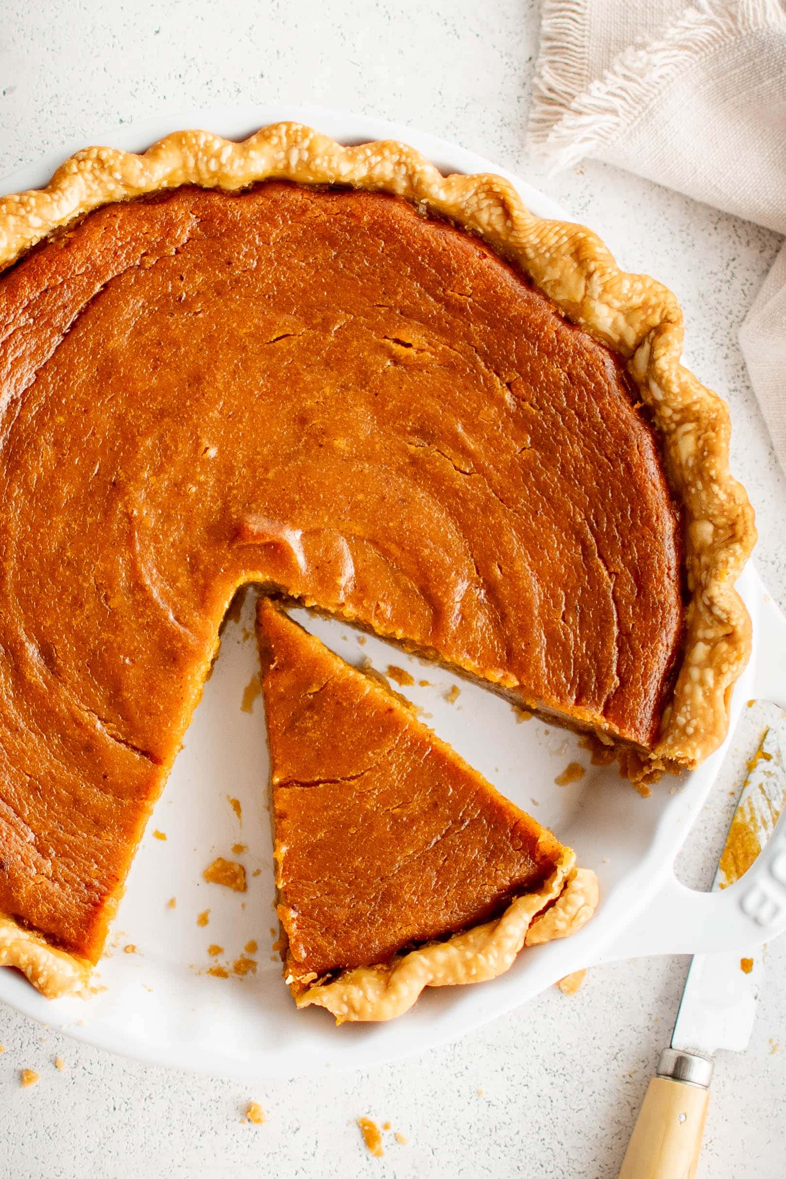 Overhead image of a sweet potato pie with one slice removed.