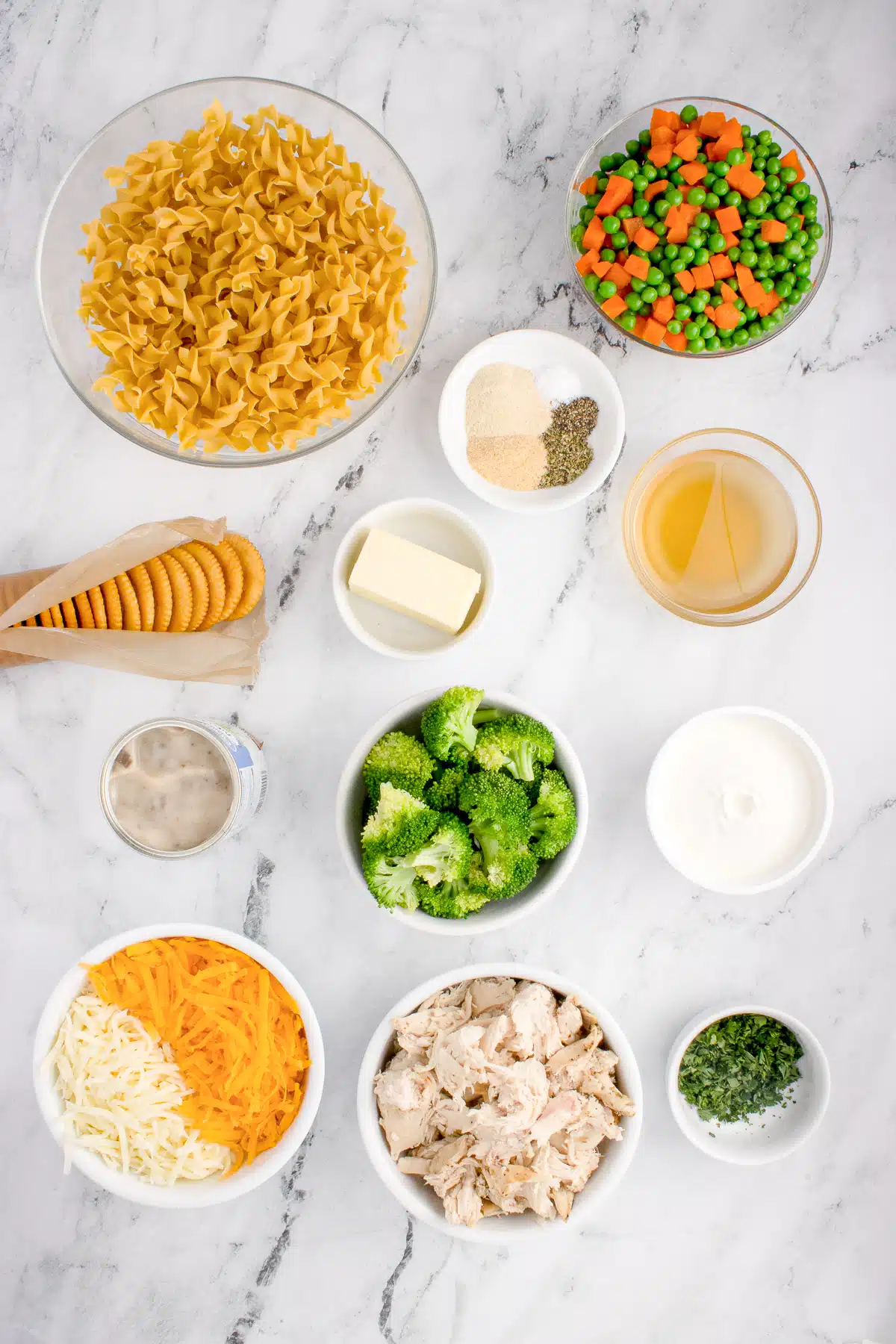 Ingredients needed to make chicken noodle casserole in individual measuring cups and ramekins.