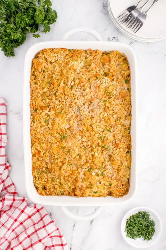 White baking dish filled with hot and bubbly baked chicken noodle casserole.