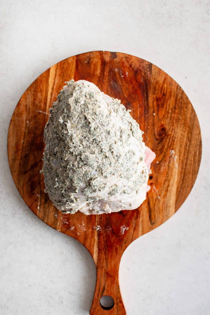 Turkey breast coated with garlic herb butter over the entire surface.