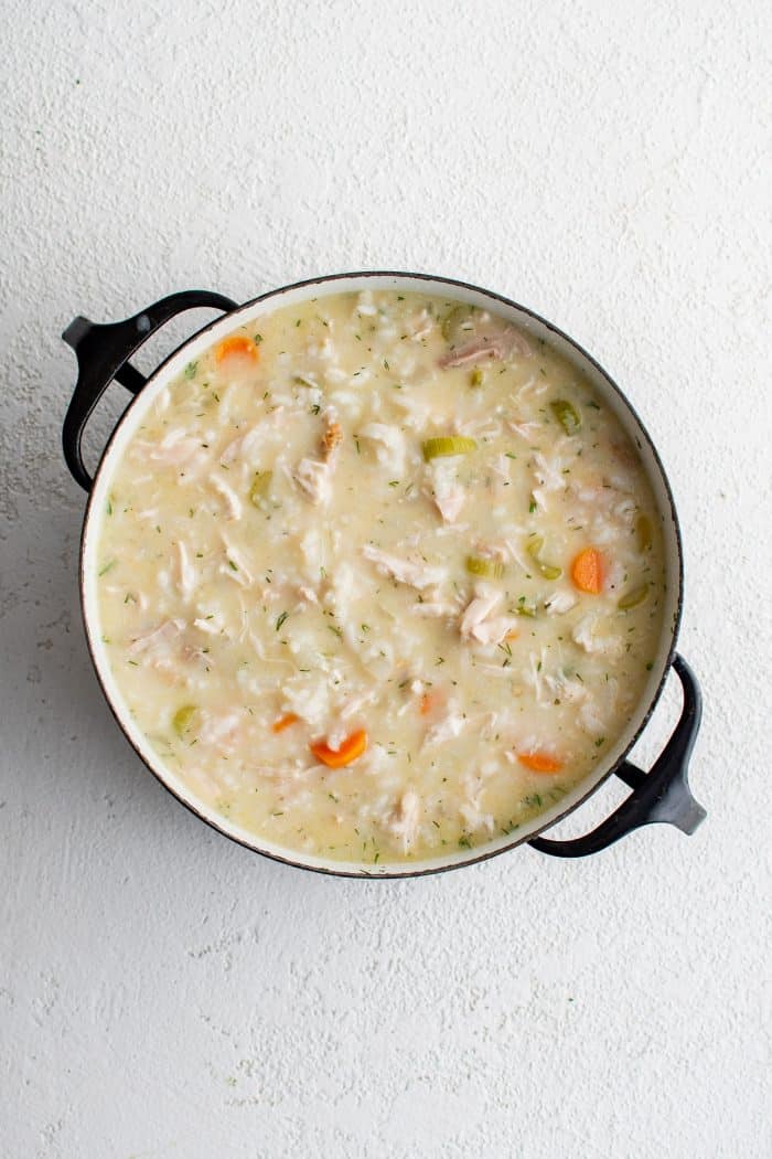 Creamy, tangy, and luscious avgolemono soup ready to be served from a large pot.
