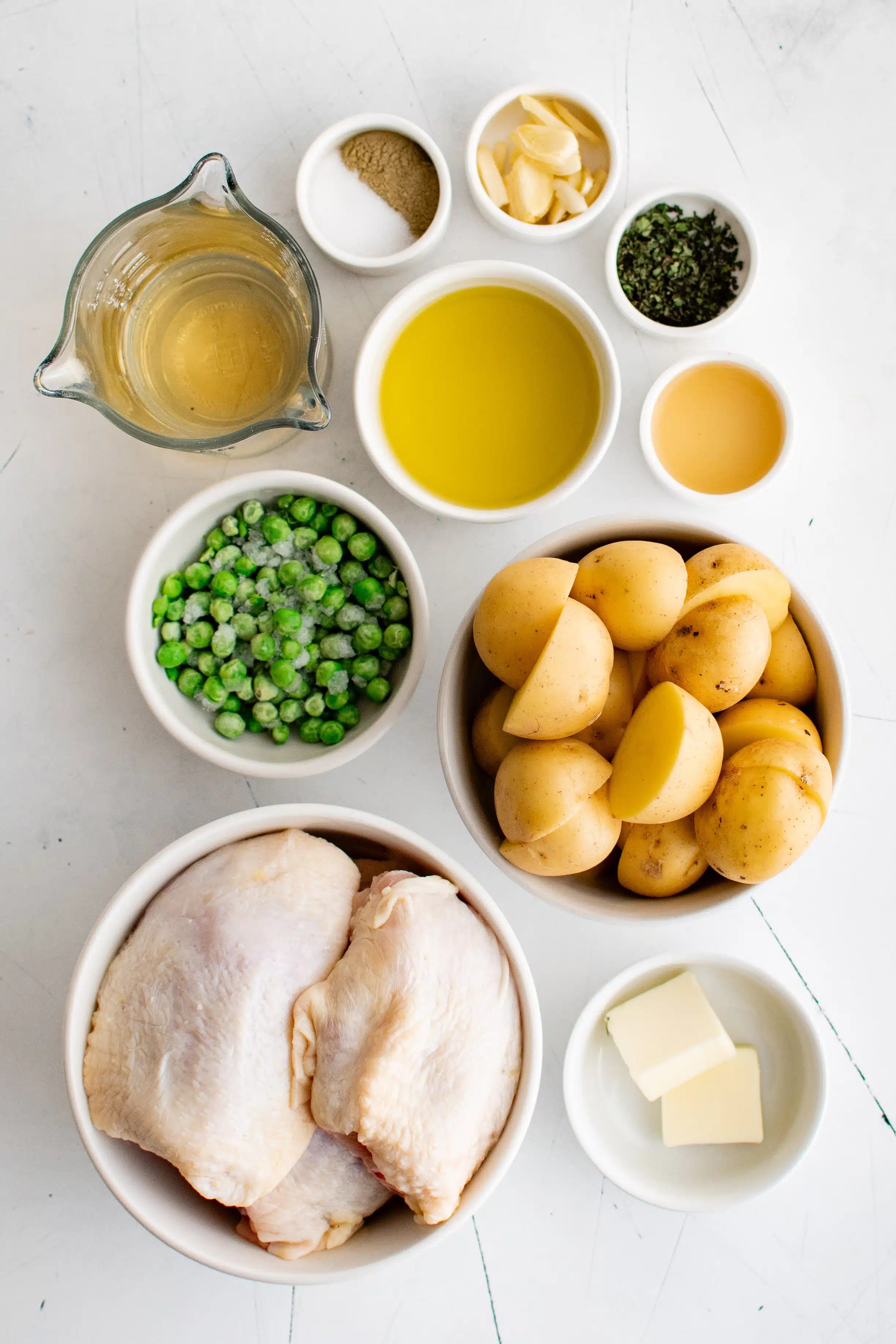 Ingredients needed to make Chicken Vesuvio Recipe in individual measuring cups and ramekins.